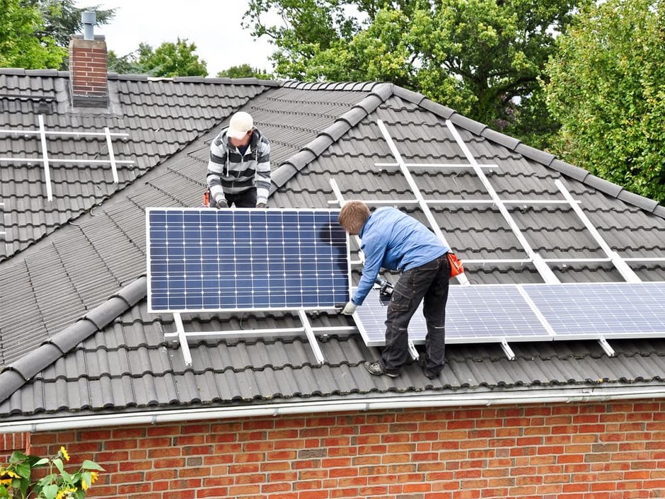 Förderungen, Männer bringen eine Photovoltaikanlage auf dem Dach an, Foto: Marco2811 / stock.adobe.com