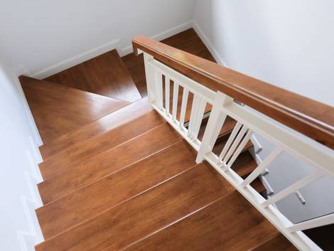 Treppenbau, DIN 18065, Holztreppe mit weißem Geländer und seitlichen Wangen. Foto: stock.adobe.com / sutichak