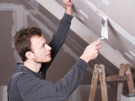 Leichtbauwand, Trockenbauwand, Mann spachtelt Gipswände an einer Dachschräge zu. Foto: Wellnhofer Designs / fotolia.de