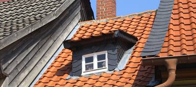 Dach, Bild eines schmalen Hauses mit einem Spitzdach mit roten Dachziegeln und einer Gaube, Foto: Matthias Nordmeyer / Fotolia.com