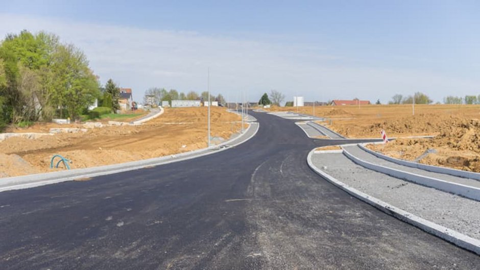 Grundstücksbewertung, Blick die Straßenflucht eines unbebauten Neubaugebiets entlang, Foto: ThomBal / stock.adobe.com