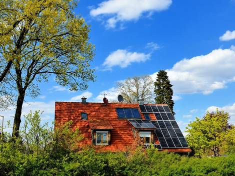 Ökohaus, Bäume werden Schatten auf ein Dach und die dort installierte Photovoltaik-Anlage. Foto: reimax16/ Adobe stock