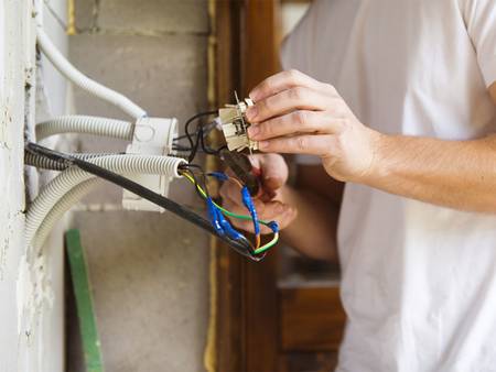 Modernisierung, Leerrohre, Mann installiert Steckdose, Foto: fotolia.de / Halfpoint