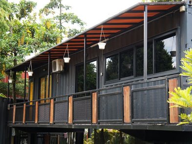 Modulhaus, Container mit überdachtem Balkon und vielen Fenstern, Foto: Aisyaqilumar / stock.adobe.com