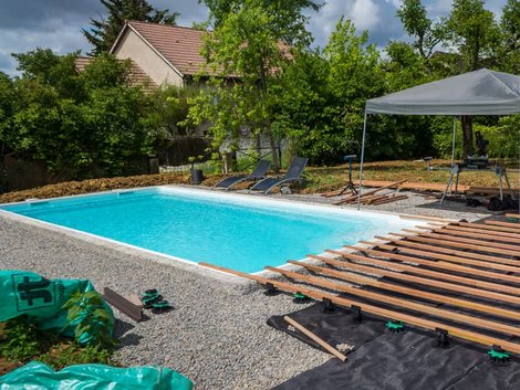 Swimmingpool, fertiges Becken, rundherum wird gerade die Querlattung für eine Terrasse montiert. Foto: Eléonore H / stock.adobe.com