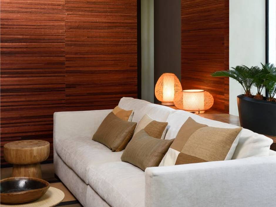 Naturtapeten, modernes Wohnzimmer mit hellem Sofa und brauner Tapete aus Bananenblättern, in horizontale Streifen geschnitten. Foto: Arte