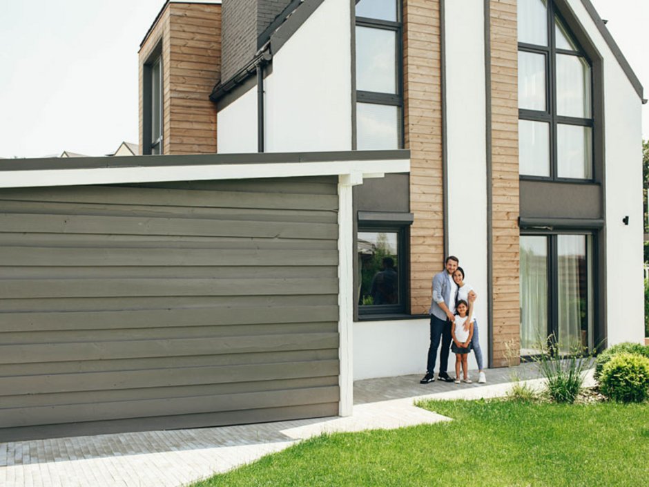 Eine glückliche Familie vor dem Neubau.